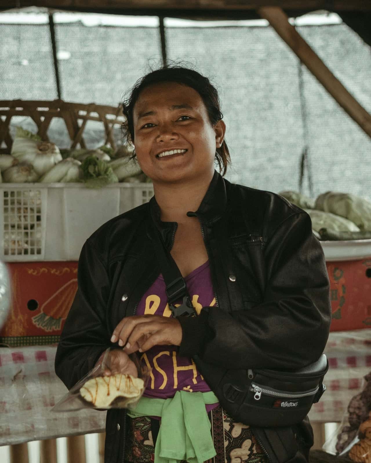 Ibu penjual sayur dan kerupuk tersenyum di lapaknya di Bali.